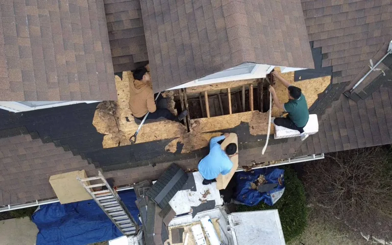 Emmendorfer crew inspecting exposed roof decking during a repair