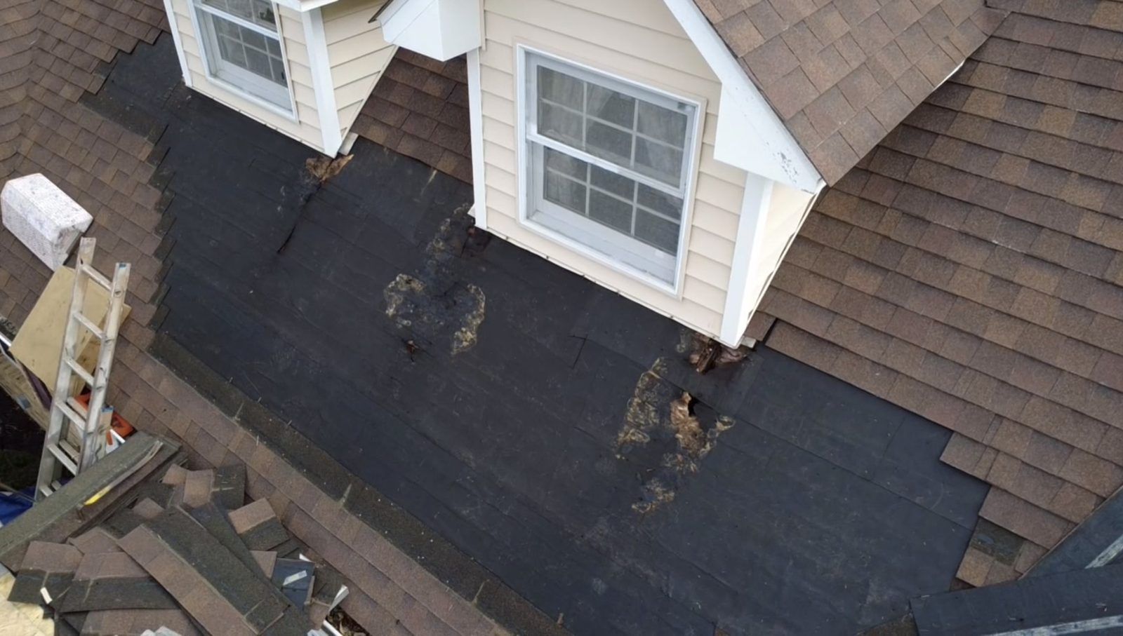 Roof mid tear-off during replacement by Emmendorfer Exteriors in Pacific, MO, drone view